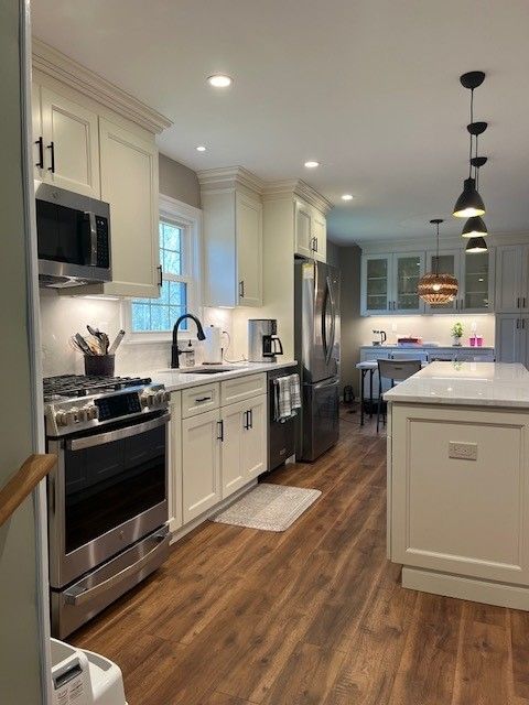 A kitchen with white cabinets and stainless steel appliances