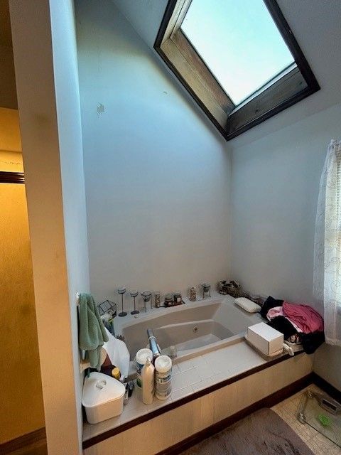 A bathroom with a skylight above the tub