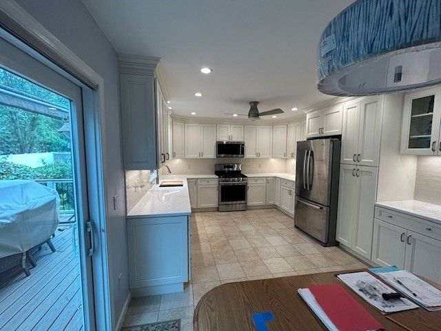 A kitchen with white cabinets and stainless steel appliances