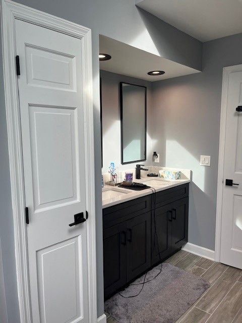 A bathroom with black cabinets and a white door