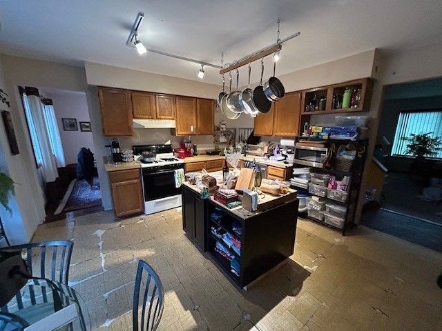 A kitchen with pots and pans hanging from the ceiling