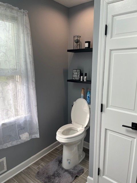 A bathroom with a toilet and a window