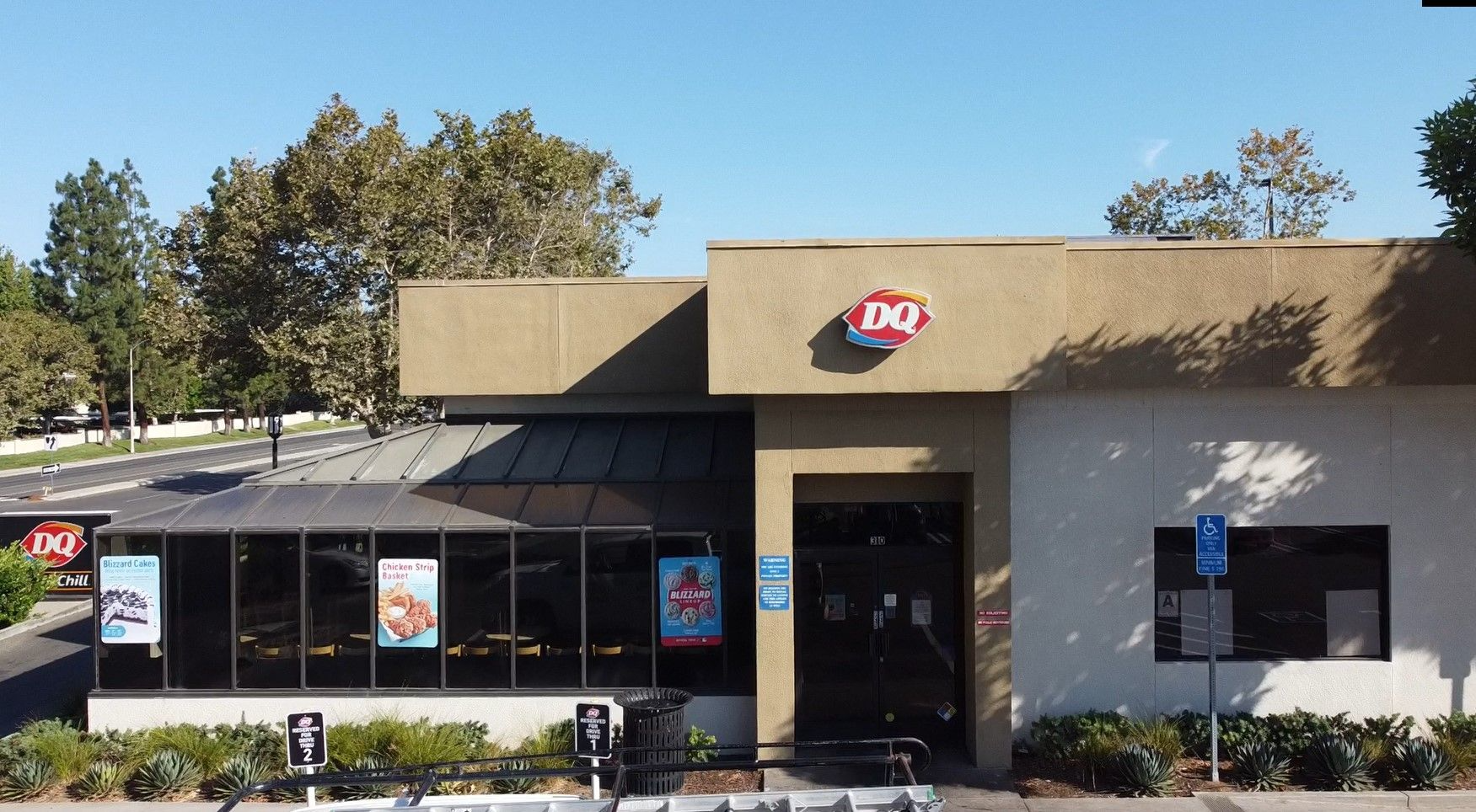 Dairy Queen restaurant with brown and white exterior, under blue sky.