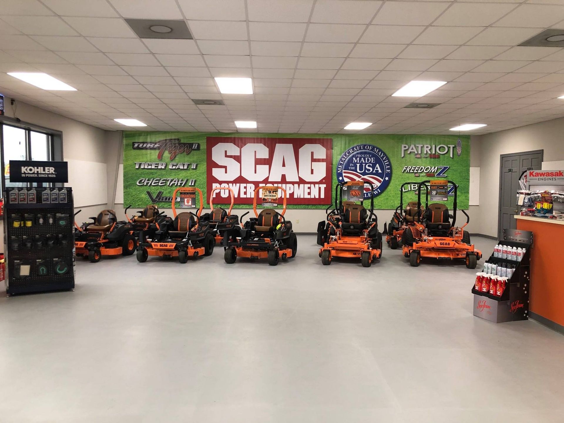 Inside a power equipment store, several orange SCAG lawnmowers are displayed.