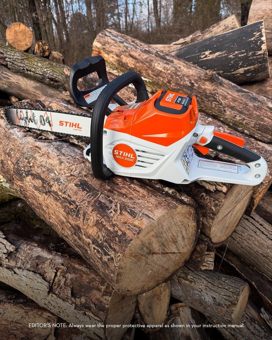 STIHL battery-powered chainsaw resting on a pile of cut logs, orange and white.