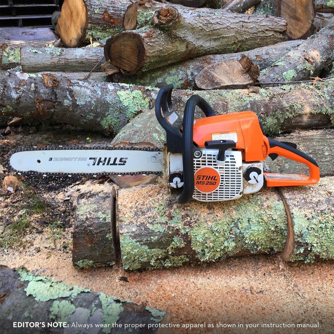 Orange and white Stihl chainsaw on cut logs.