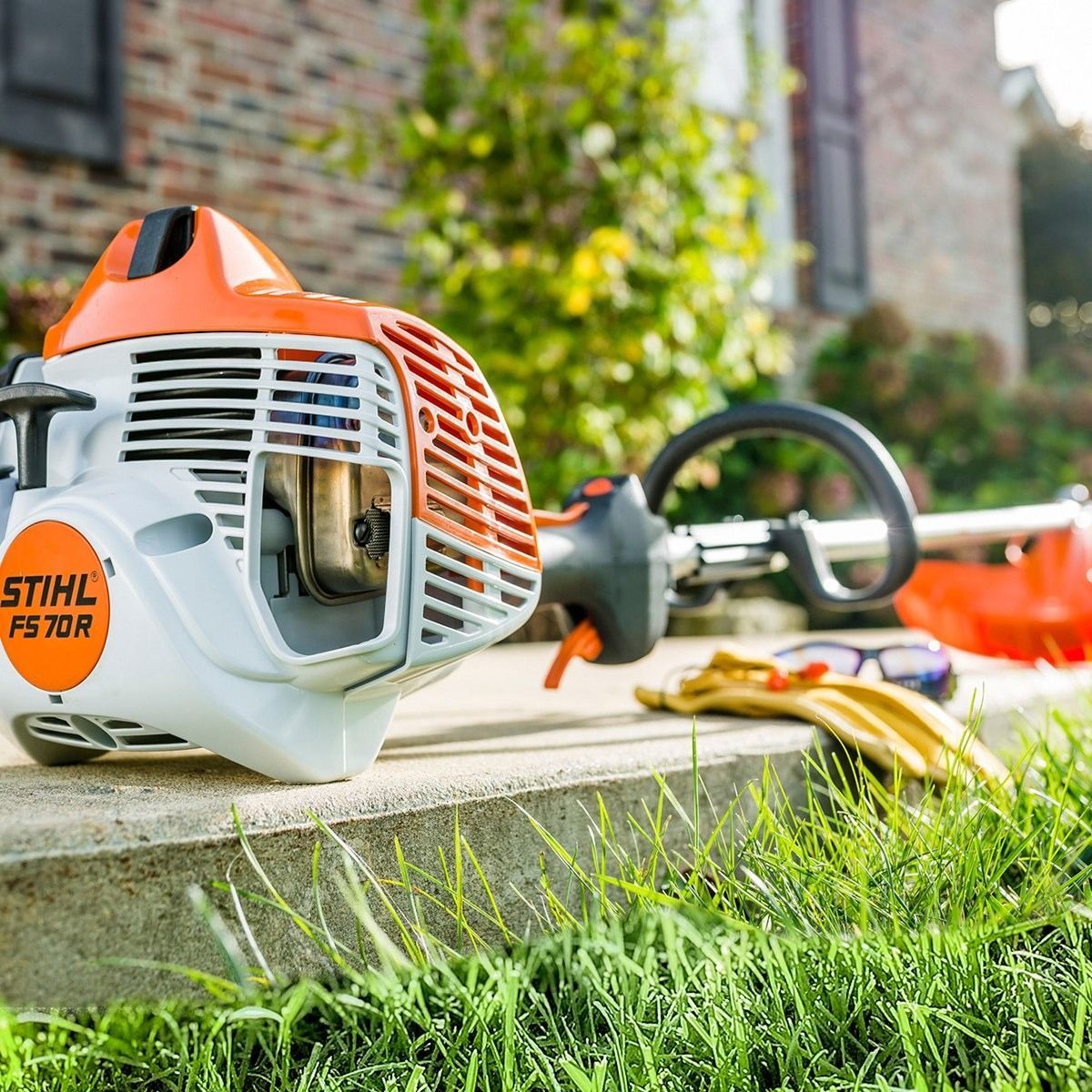 Stihl FS 70 R string trimmer on a concrete step with grass in the foreground.