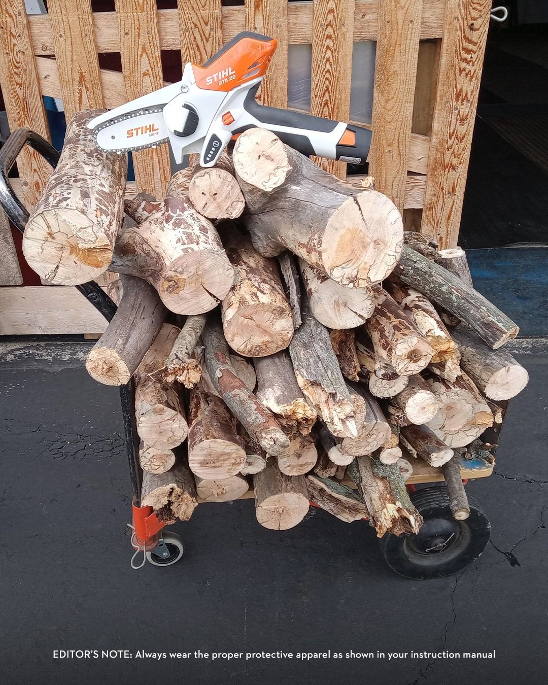 Cart piled high with logs, a mini chainsaw sits on top.