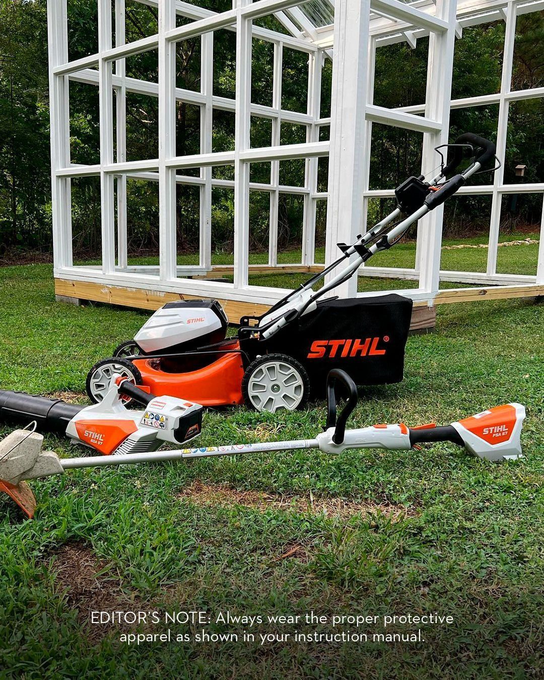 Lawn care equipment (mower, trimmer) in front of a white frame structure on green grass.