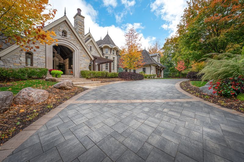Stone mansion driveway with autumn trees and landscaped gardens