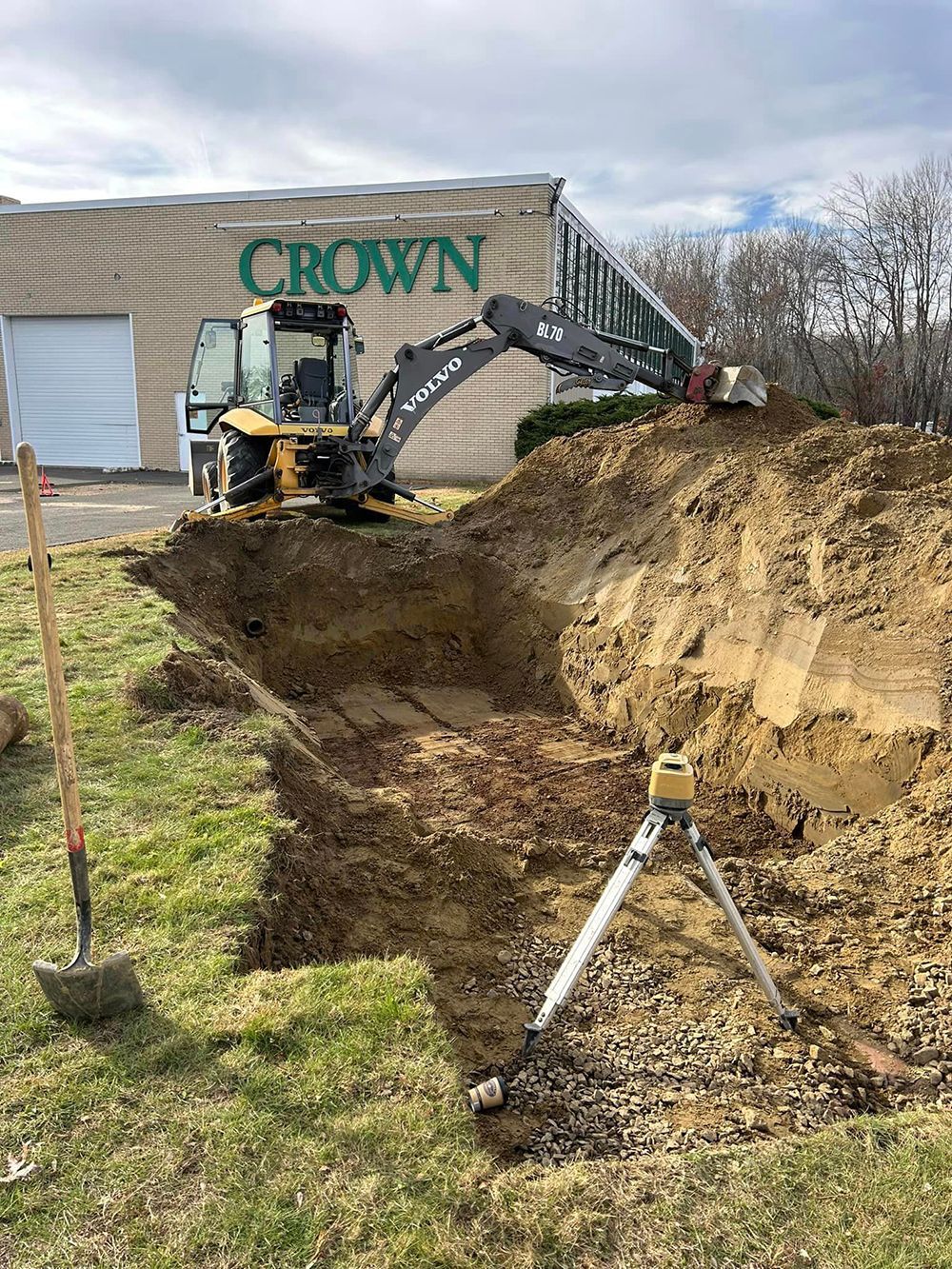 A bulldozer is digging a hole in the ground in front of a building
