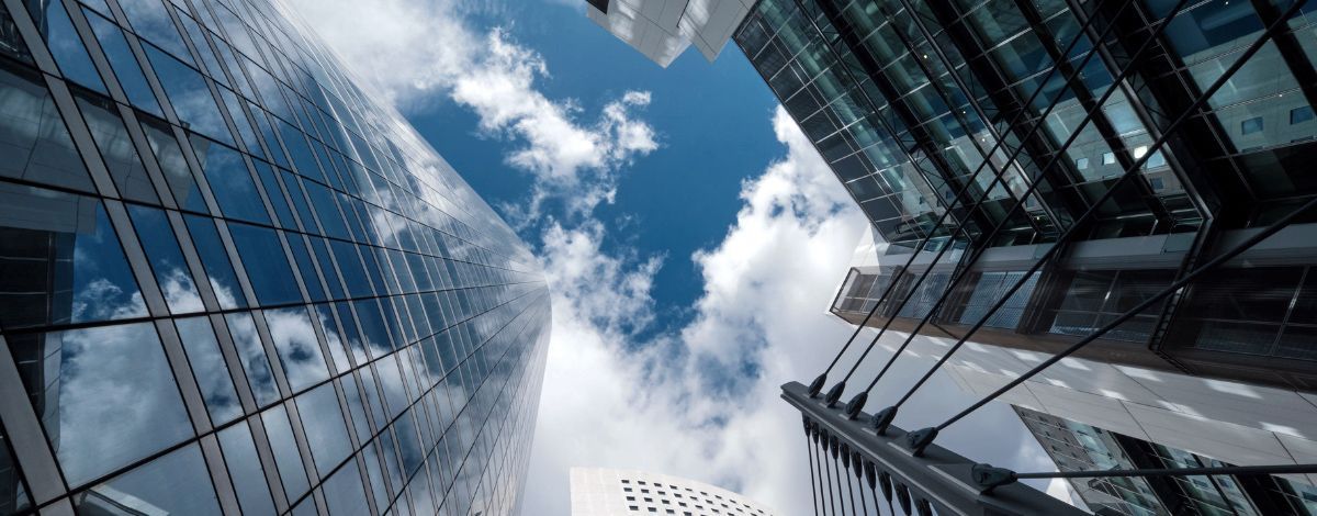 View of skyscrapers against a bright blue sky with clouds.