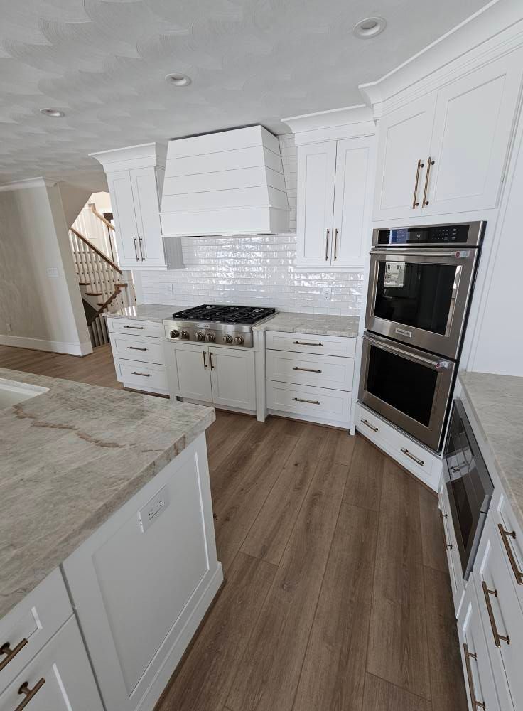 A kitchen with white cabinets and stainless steel appliances.