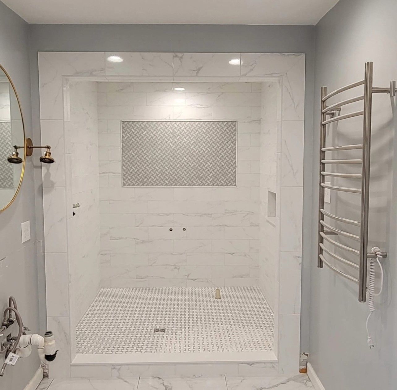 A bathroom with a walk in shower and a towel rack.