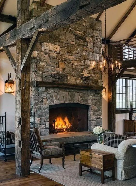 A living room with a stone fireplace and wooden beams
