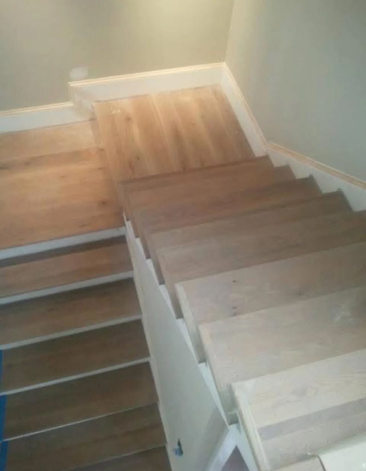 A staircase with wooden steps and a white railing.