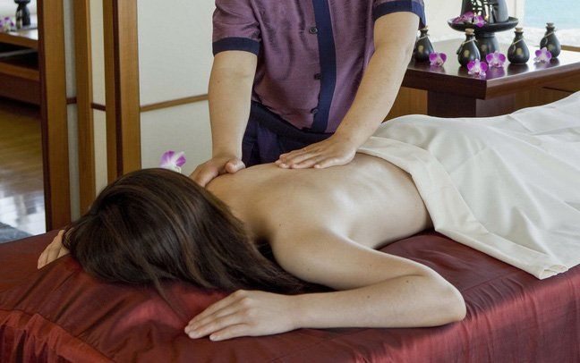 A woman is laying on a massage table getting a massage.