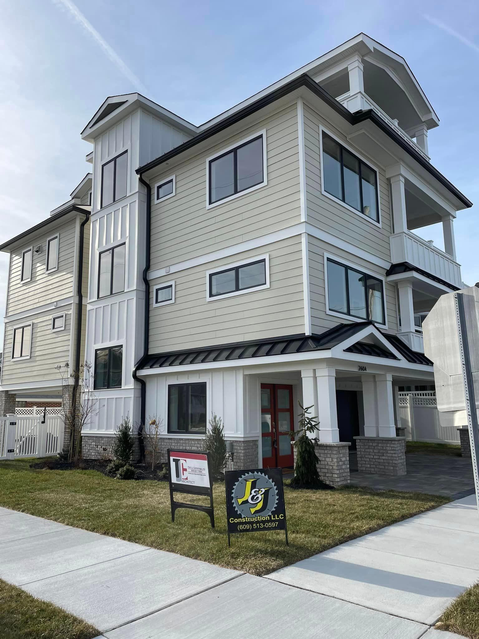 A large house with a lot of windows and a sign in front of it.