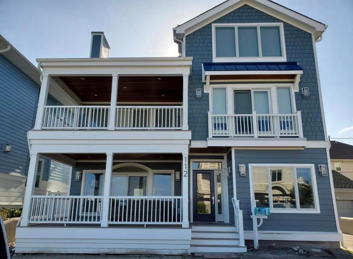 A large blue house with a lot of windows and balconies