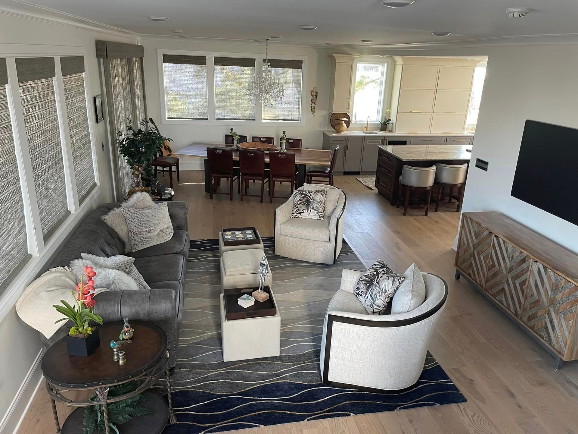 A living room with a couch, chairs, tables and a television.