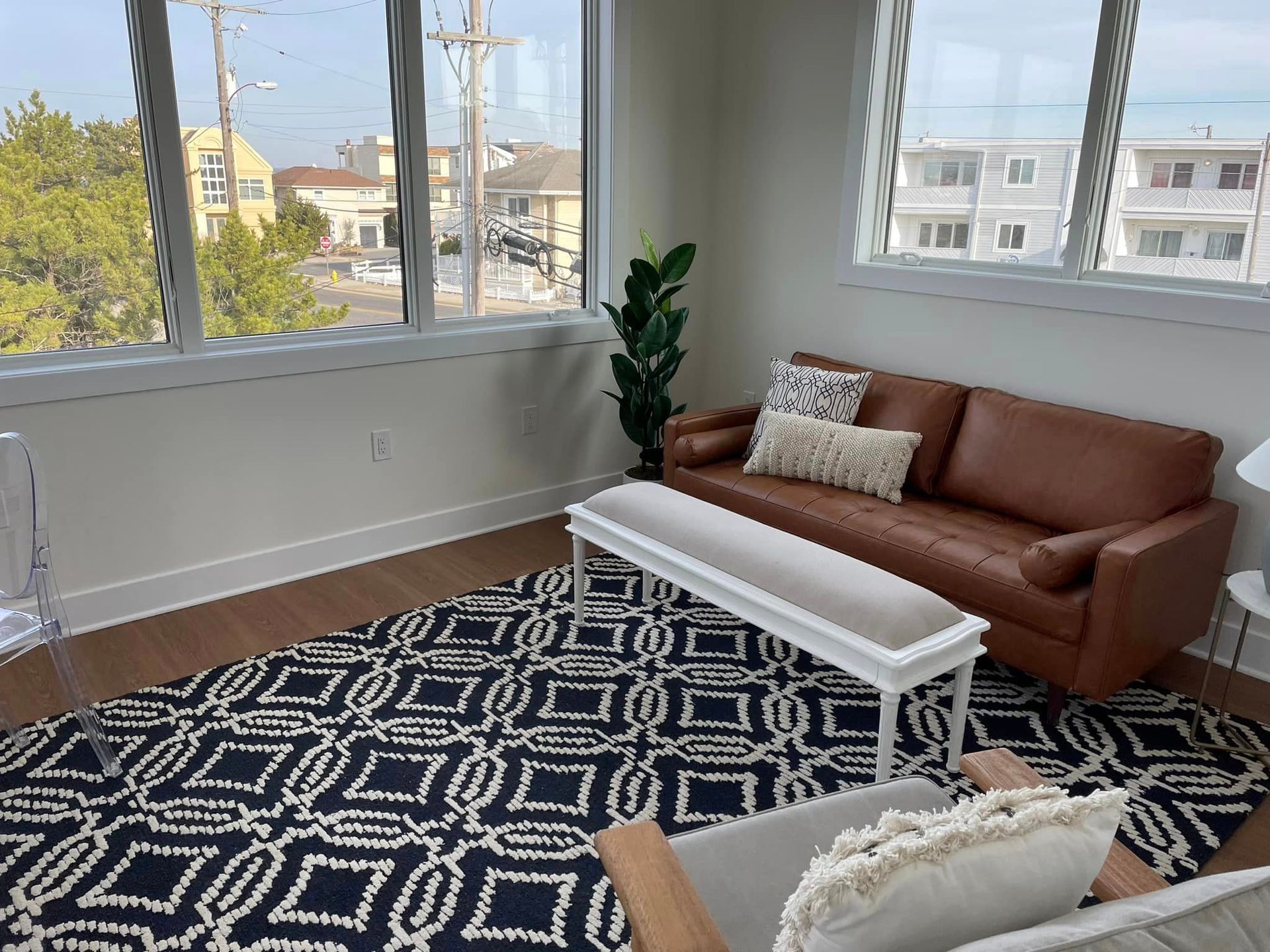 A living room with a couch, chair, coffee table and rug.