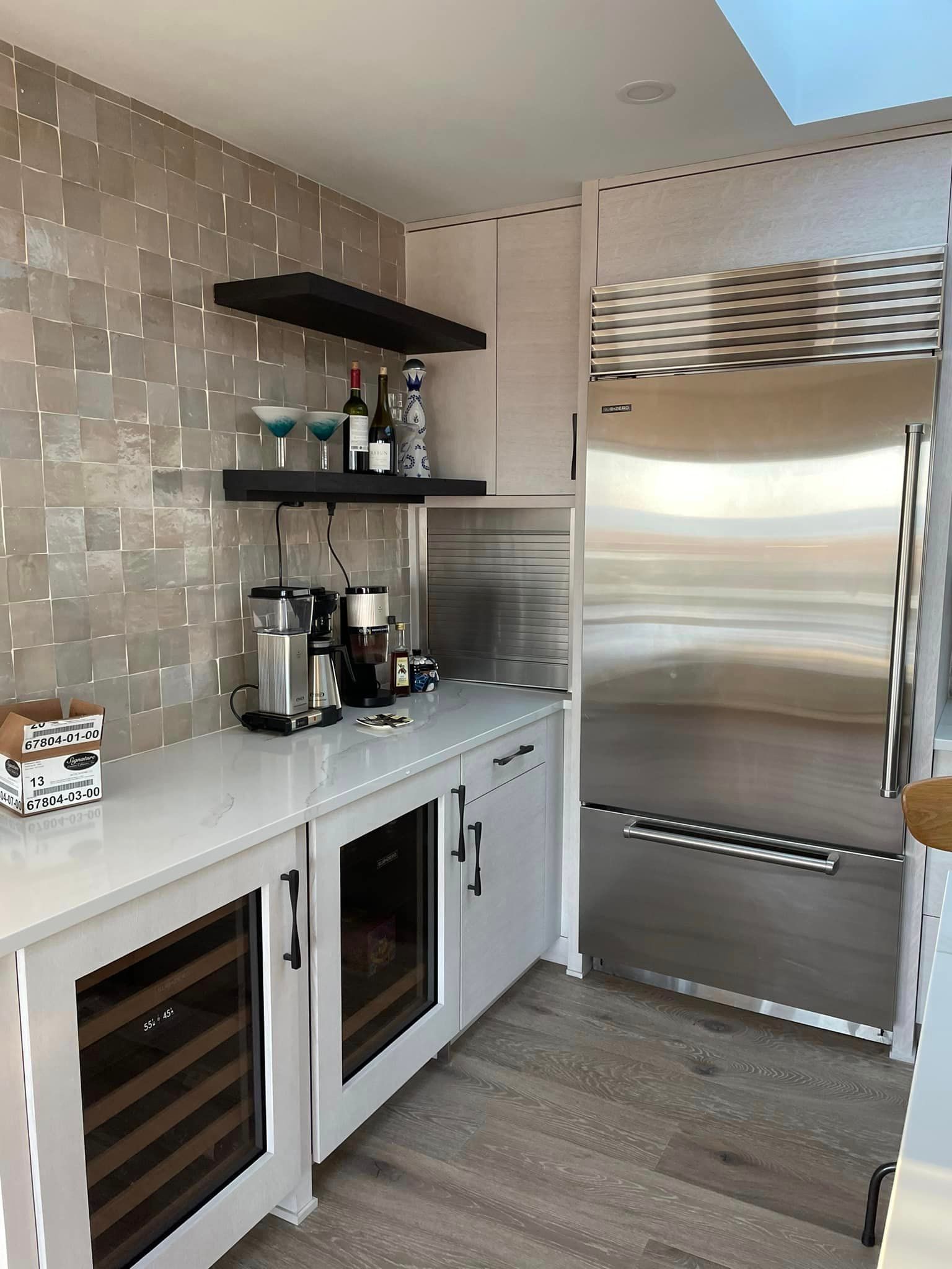 A kitchen with stainless steel appliances and a wine cooler.