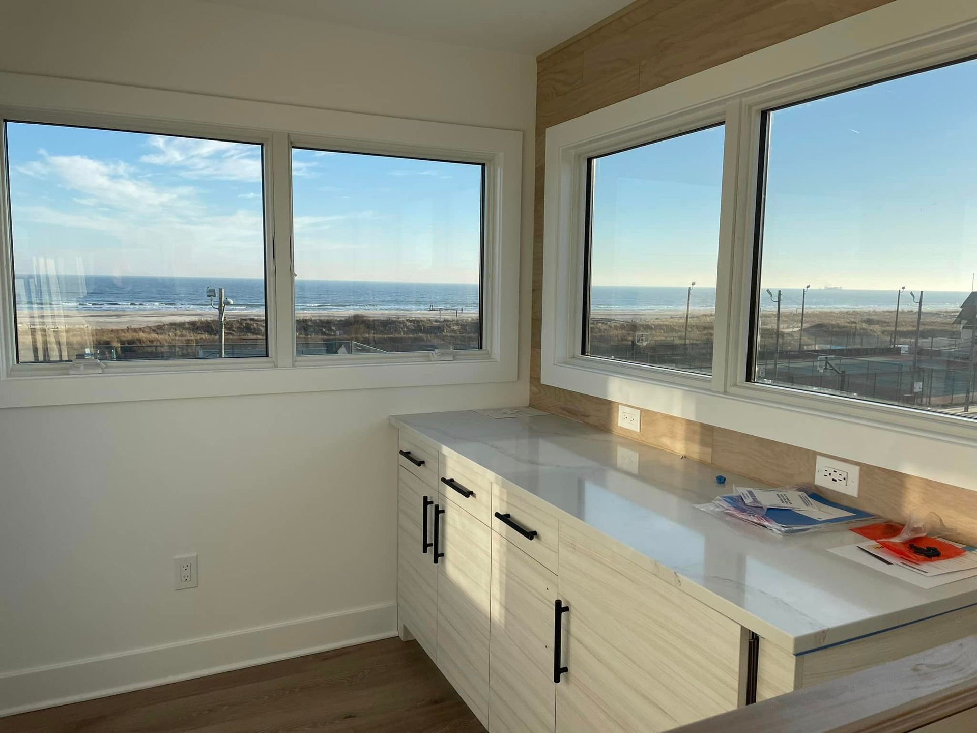 A kitchen with a lot of windows and a view of the ocean.
