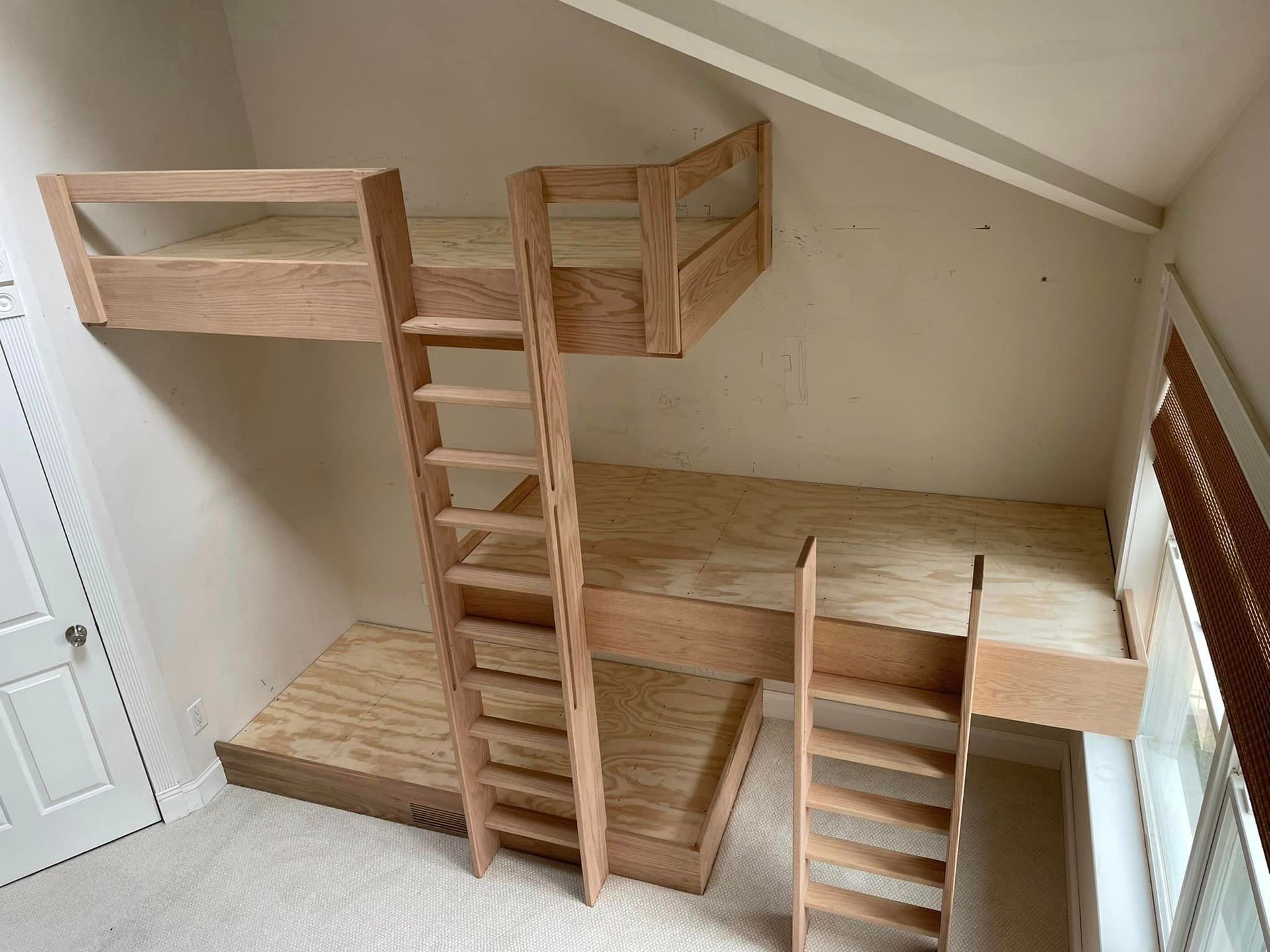 A wooden bunk bed with stairs in a room.