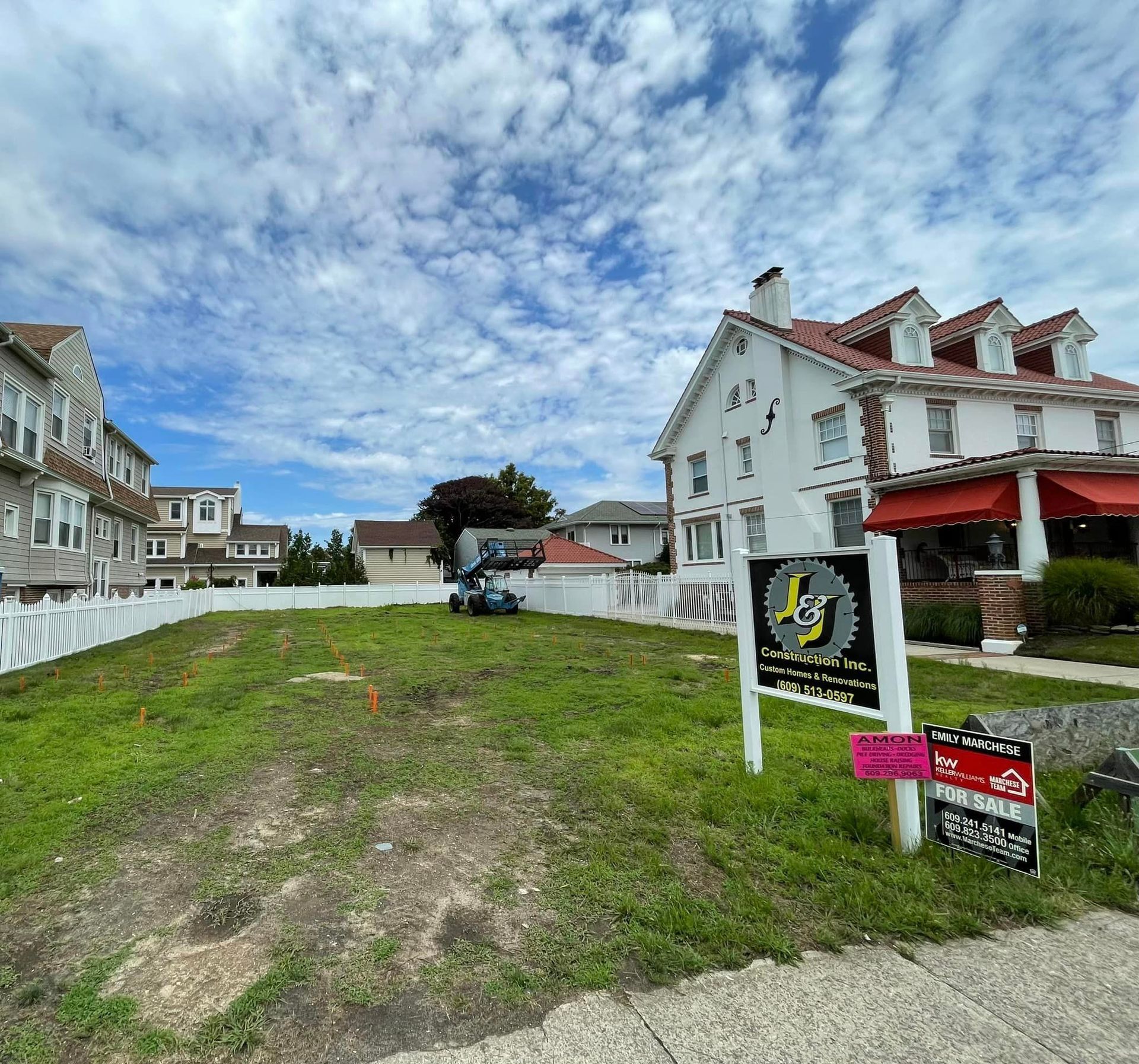 A lot with a house in the background and a for sale sign in the foreground.