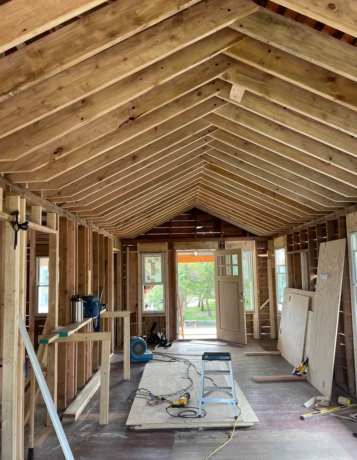A house is being built with wooden beams and a vaulted ceiling.