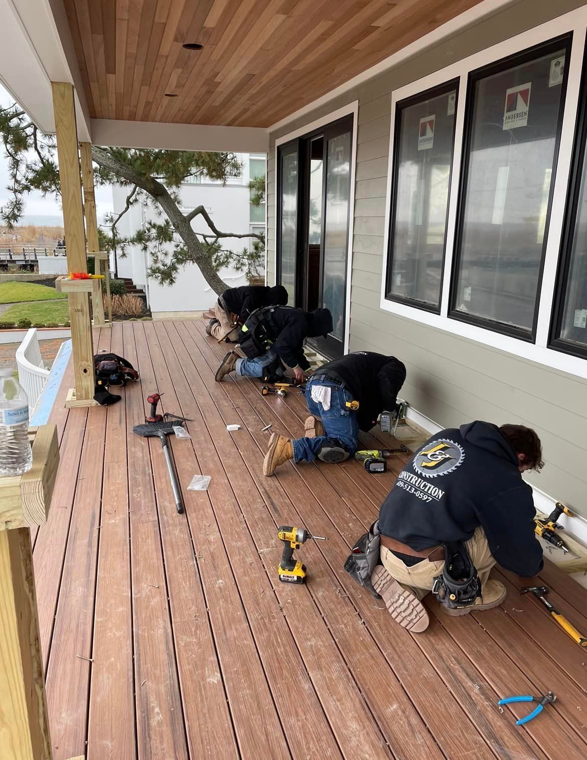 A group of men are working on a wooden deck.