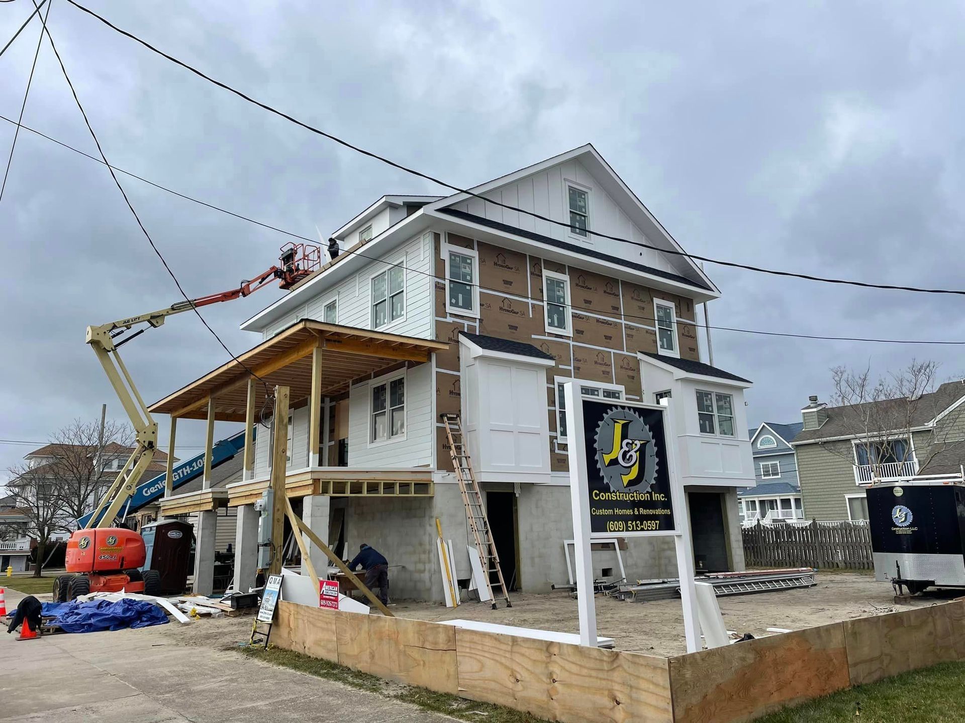 A house is being remodeled with a sign in front of it.
