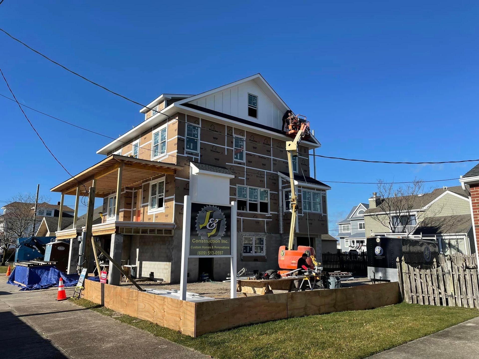 A large house is being remodeled on a sunny day.