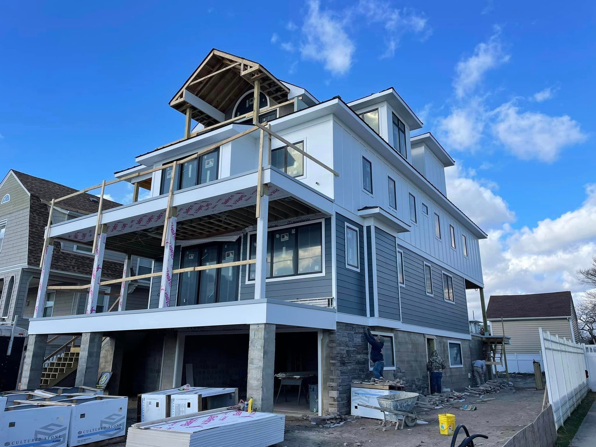 A large house is being built on a sunny day.