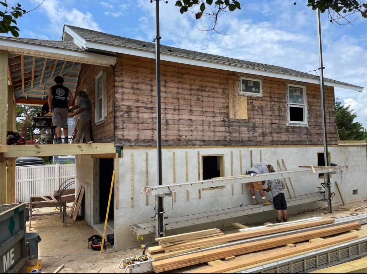A group of men are working on a house under construction.