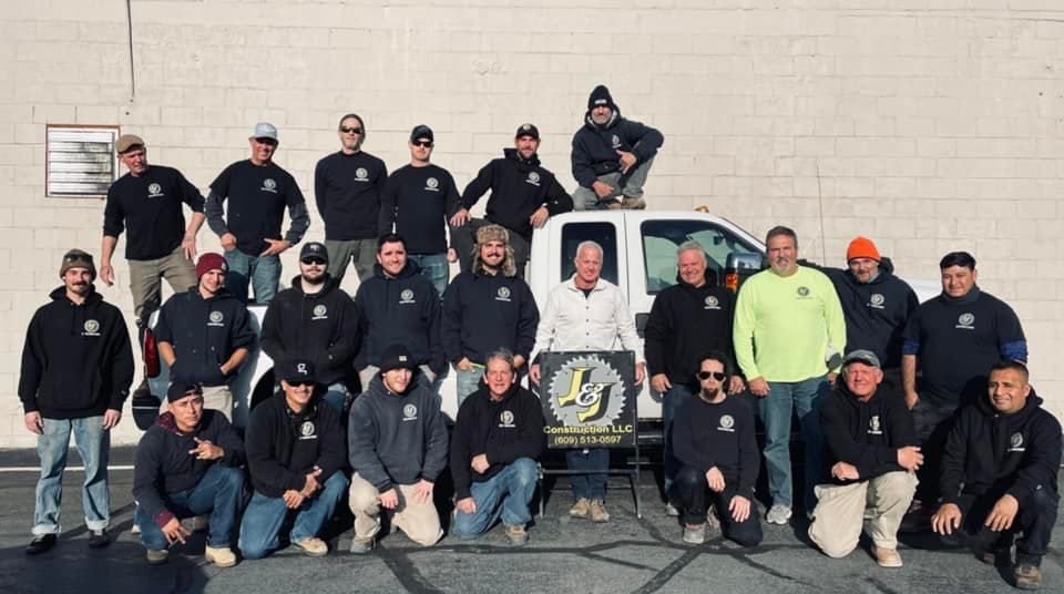 A group of men are posing for a picture in front of a truck.