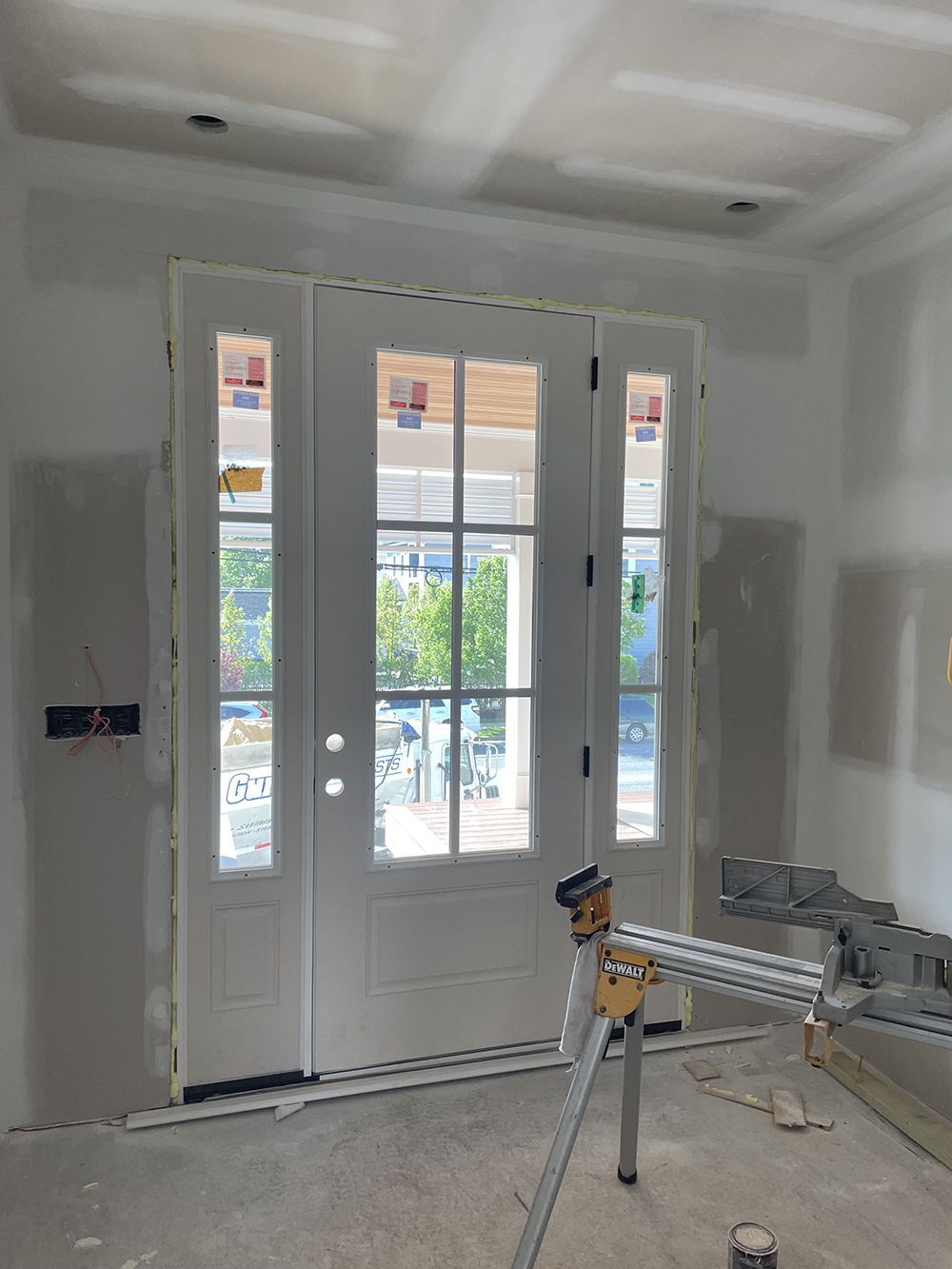 A room with a door and a tripod in it.