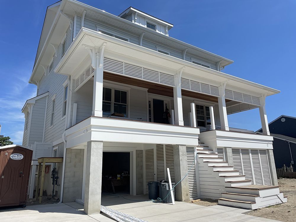 A large white house with a large porch and stairs