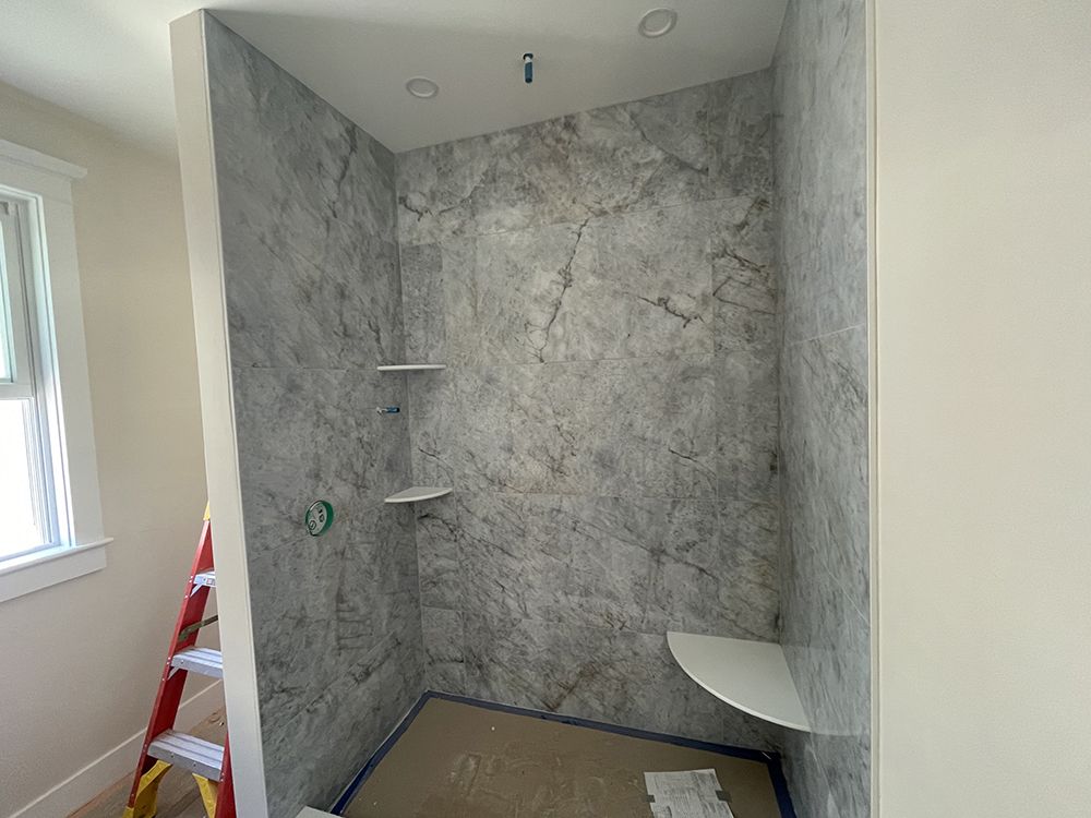 A bathroom with a walk in shower and a ladder.