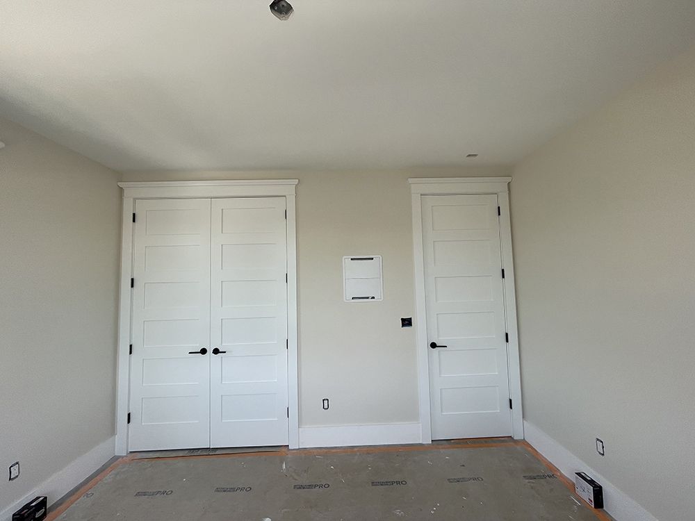 An empty room with white walls and white doors
