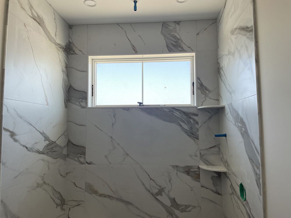 A bathroom with marble tiles and a window