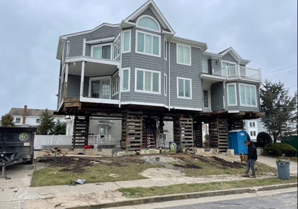 A large house is being moved on stilts.