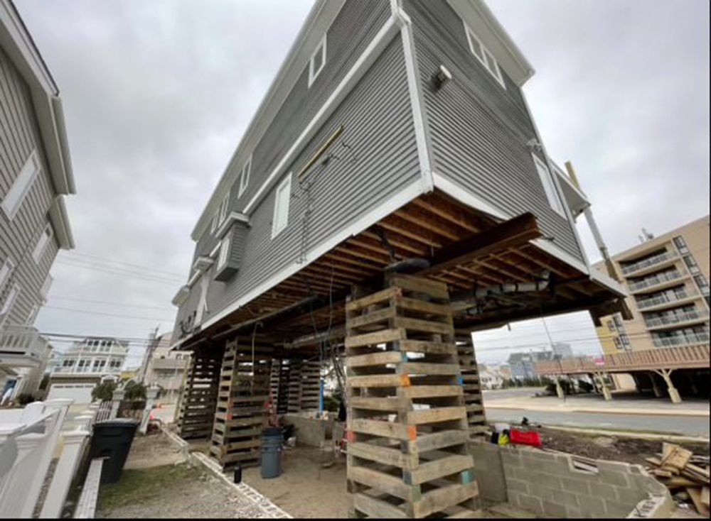 A house is being lifted into the air with pallets.