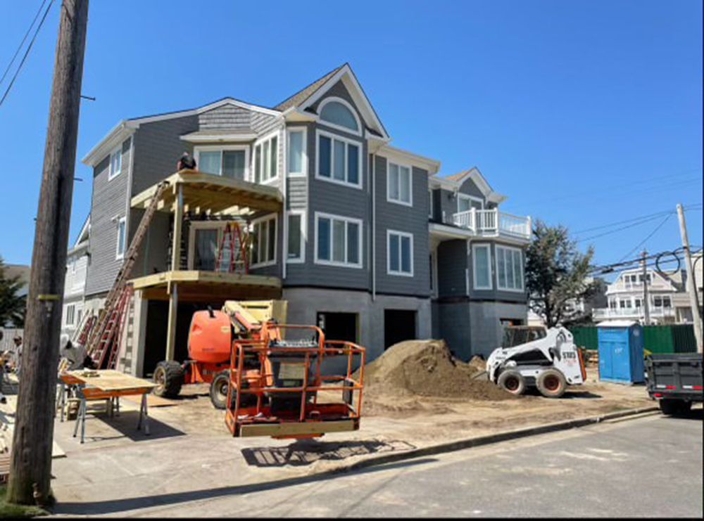 A house that is being built with a bulldozer in front of it