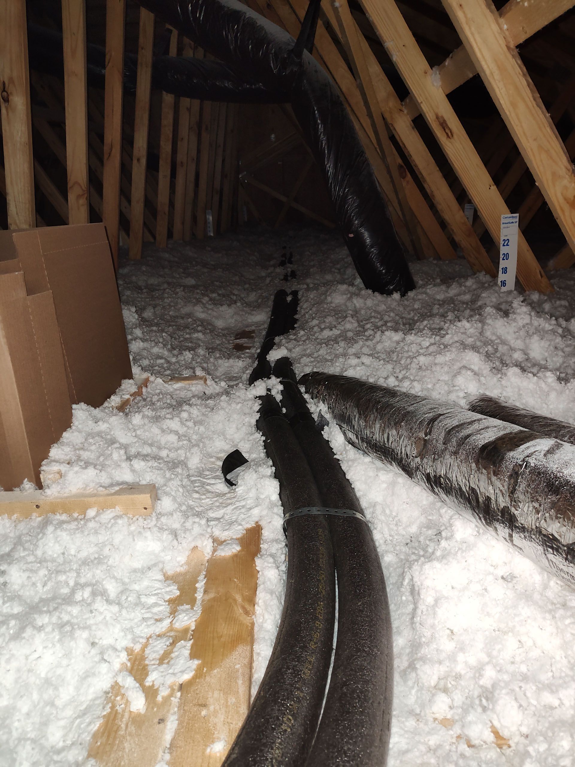 A bunch of pipes are laying in the attic