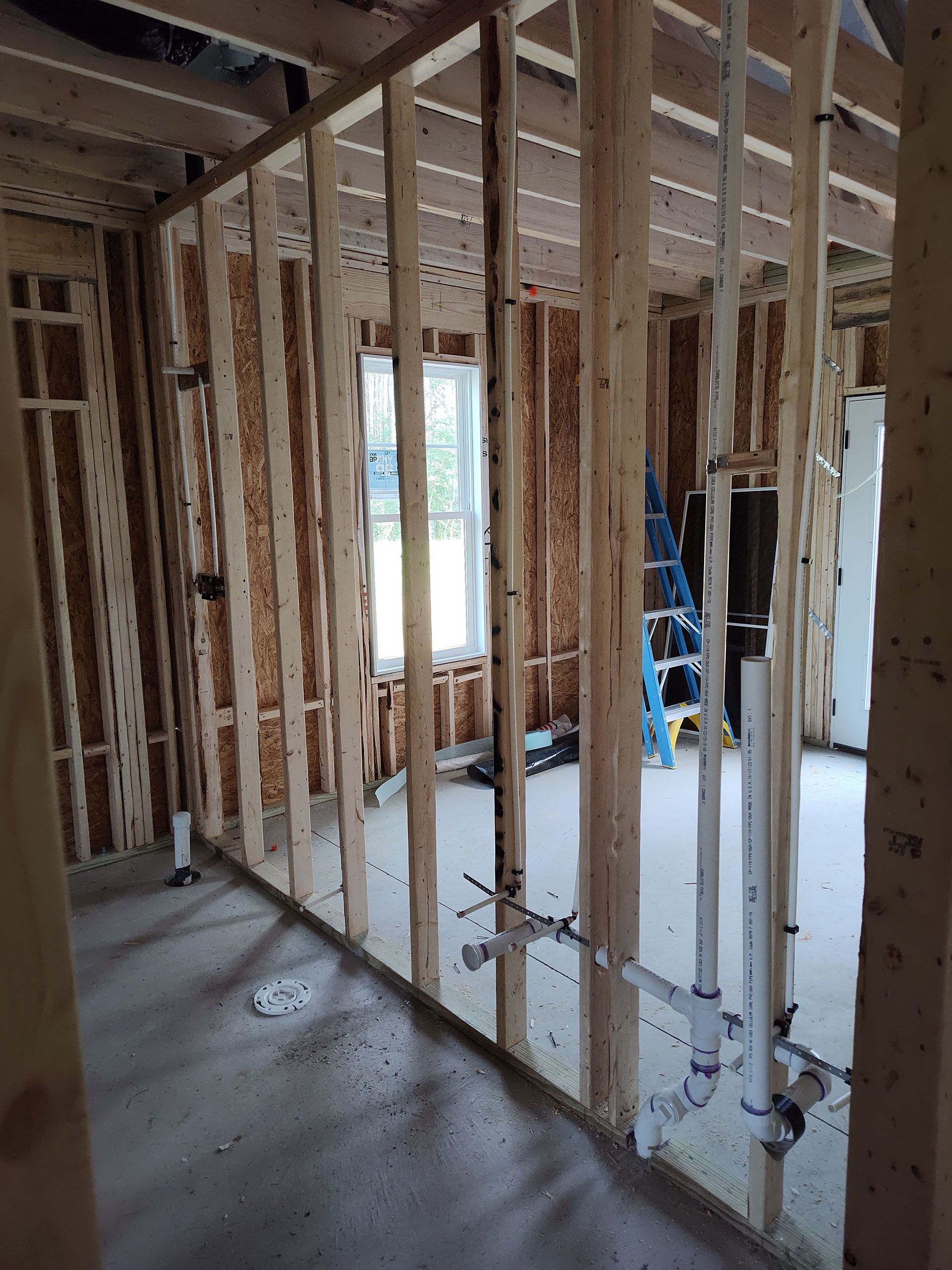 A room is being built with wooden beams and pipes.