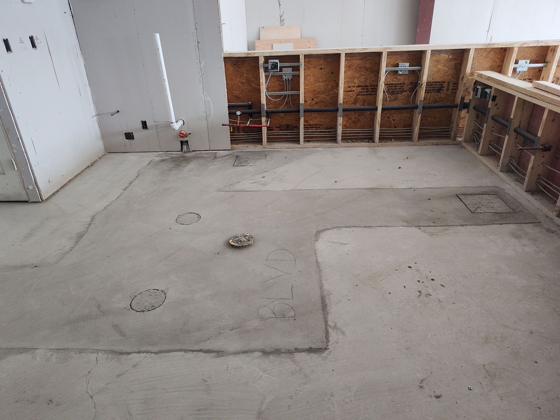 A room with a concrete floor and a wooden wall