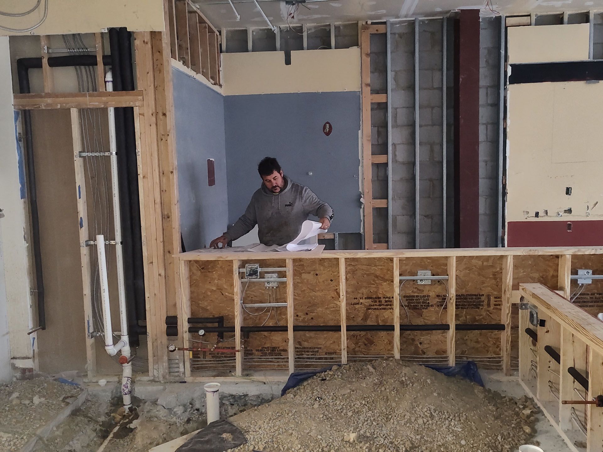 A man is standing in a room that is being built