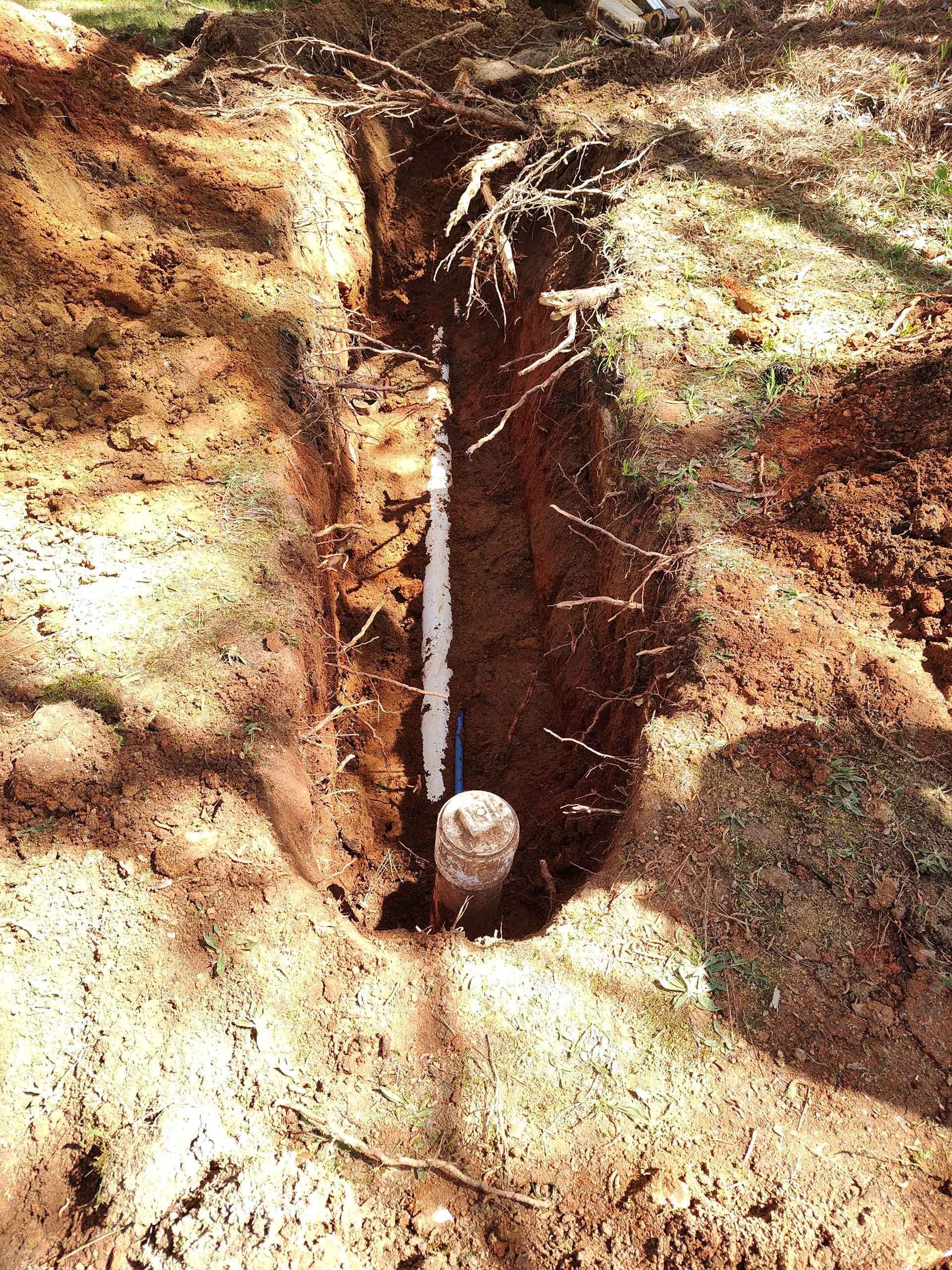 A hole in the ground with a pipe in it.