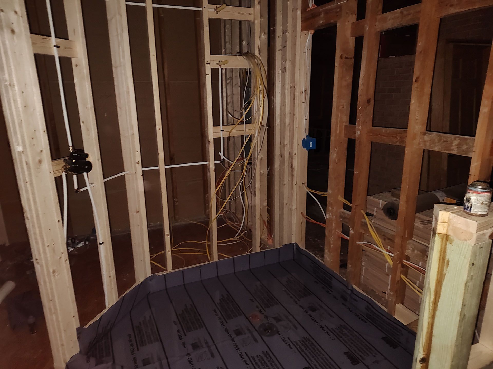 A room with wooden walls and plumbing is under construction